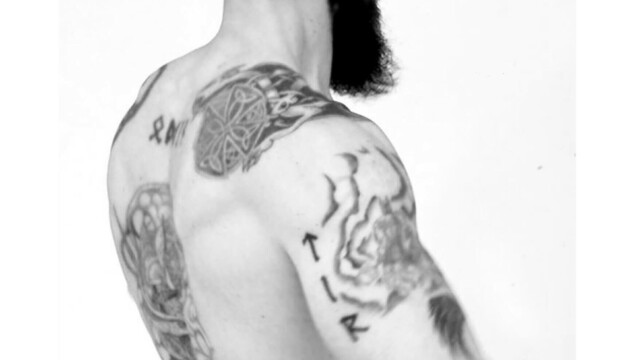 Portrait 3/4 dos d'un homme tatoué, noir et blanc